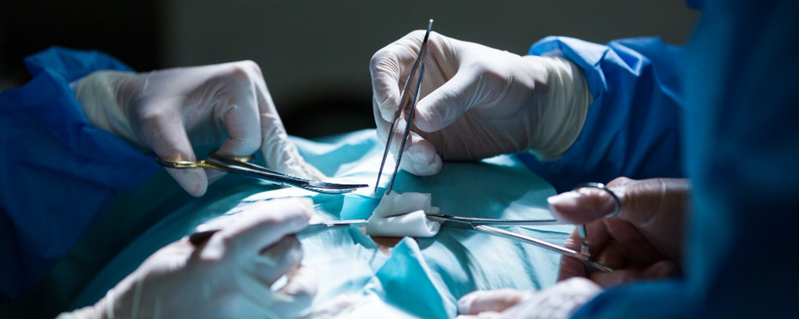Surgeons performing hernia repair in an operating room